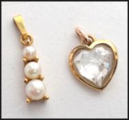 Two 9ct gold hallmarked pendants the first in the form of a heart with a mounted coloured cut