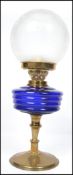 An early 20th century brass and blue glass oil lamp complete with a frosted glass shade. The brass