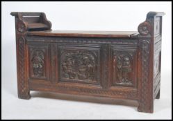 A 19th century Victorian oak open backed hall settle chest / window seat having carved decoration