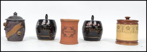 A group of early 20th century ceramic tobacco jar to include a pair having a black ground with