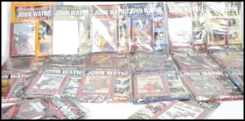 A large collection of magazine and DVDs relating to John Wayne, each magazine and DVD still