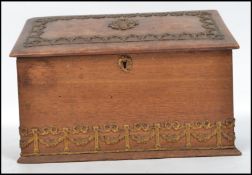 A Victorian mahogany desk tidy with embellished swags and column borders having hinged top with
