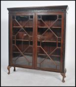 An Edwardian mahogany display cabinet being raised on cabriole legs with twin glass bookcase cabinet