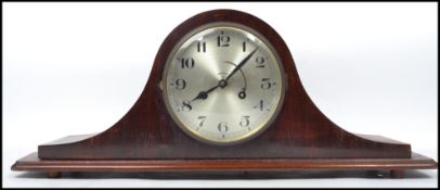 An Edwardian mahogany inlaid napoleons hat mantel clock having silvered dial with brass inset