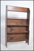 A 1920's oak open window bookcase cabinet having shaped sies with fixed 5 shelves, the top with