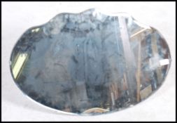 A vintage mid 20th century bevelled glass frame less mirror having a scalloped edge with wooden