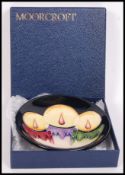 A Moorcroft ceramic tube lined pin dish coaster decorated in the Xmas Candlelight pattern with