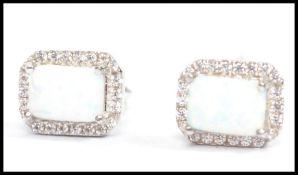 A pair of ladies silver and opal earrings. The opals on prong settings complete with post backs in