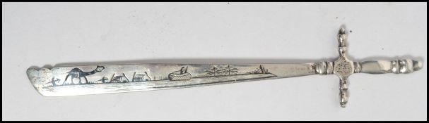 An Indian silver (tests) letter opener in the form of a sword, the shaped blade depicting scenes