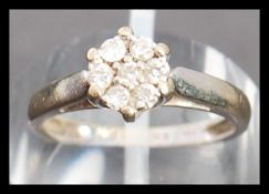 A hallmarked 18ct white gold and diamond ring. The ring having 7 diamonds in a cluster setting.