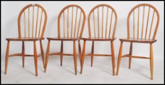 A set of four Ercol hoop back dining chairs in beech and elm having the blonde finish. measures 88 x