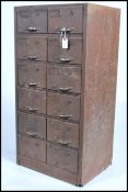 A retro mid century industrial metal filing cabinet having 12 drawers with pull handles and index
