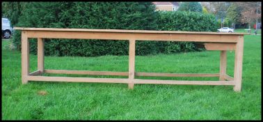 A large early 20th century stripped pine 3m long French refectory dining table. Raised on squared