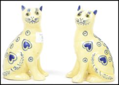 A pair of ( 2) 20th century French Galle style cats each with yellow and blue ground decoration with