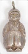 A silver plated novelty rattle in the form of a child with bail loop atop. Measures 8 cm high, 3.5