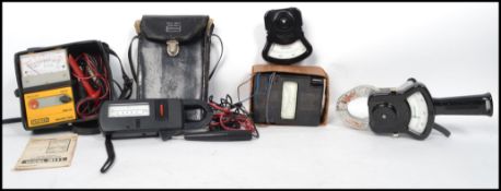 A collection of vintage meters to include a hand wind metter, 3 Tong Test meters and a Robin Meter