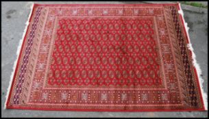 A large Iranian / Persian Bokhara carpet - rug having red ground with geometric decoration and