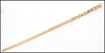 A mid 19th century scrimshaw carved whalebone walking cane with a marine ivory pommel carved as a