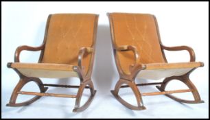 A pair of 20th century Regency revival mahogany rocking chairs having shaped arms and upholstered
