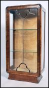 A 1930's Art Deco walnut upright china display cabinet. Raised on shaped plinth base with single