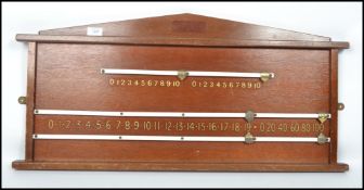 A vintage 20th century billiards / snooker scoreboard with brass moving markers and sloped top.