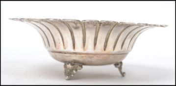 A sterling silver 925 stamped bon bon dish of scalloped form raised on tripod feet. Measures 5 cm