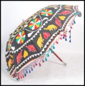 A stunning retro 20th century large table Anglo Indian parasol on red ground with brightly
