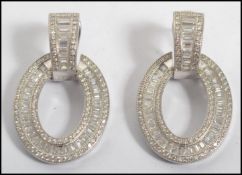 A pair of ladies silver and cz adorne hoop / creole shaped earrings, adorned with baguette cut white