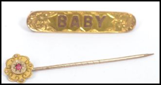 A Victorian 9ct gold stick pin brooch with garnet stone in a star setting along with a 9ct gold baby