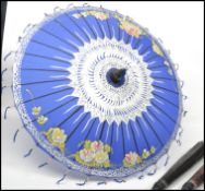 A group of three vintage 20th century Oriental parasols having tapering wooden shafts with typical