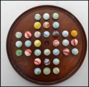 A 19th century Victorian glass marble solitaire set with wooden circular board. Measures 21 cm