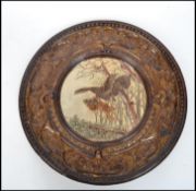 A large believed German black forest ceramic charger depicting a dog attacking a pheasant in