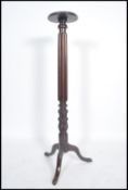 A 19th century tall oak carved torchere, with acanthus and scroll carved decoration upon a turned