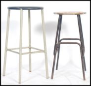 Two vintage retro 20th century industrial machinist stools of tubular form one having makers