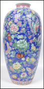 A 20th century Oriental Chinese ceramic vase having a blue ground decorated with flowers and