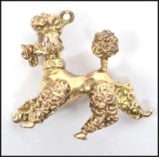 A hallmarked 9ct gold figurine of a poodle dog with garnet stone eyes. Weighs 12.4 grams. Measures