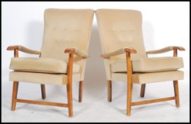 A pair of retro 20th century open framed beech wood fireside armchairs each being upholstered with a
