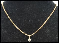 A hallmarked 9ct gold and diamond pendant necklace. The necklace being strung with a diamond cluster