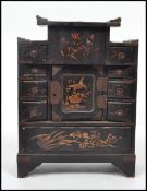 An early 20th century  Japanese black lacquer alter style jewellery box having an arrangement of
