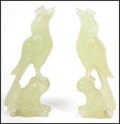 A pair of Chinese 20th century carved jade figurines of songbirds raised in perch plinth bases to