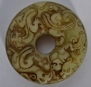 An Oriental jade carved bi of roundel form with ho