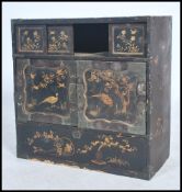 A 19th century Chinese / Japanese asiatic lacquered cabinet being black with gilded scenes and