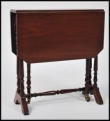 An Edwardian mahogany drop leaf / occasional table raised on turned legs united by stretchers on
