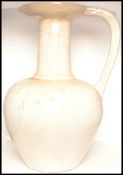 A large floor standing white glazed amphora - ewer vase having a bulbous body with large handle,