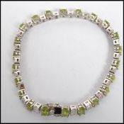A 20th century ladies silver and peridot line / tennis bracelet with clasp. Inset peridots spaced