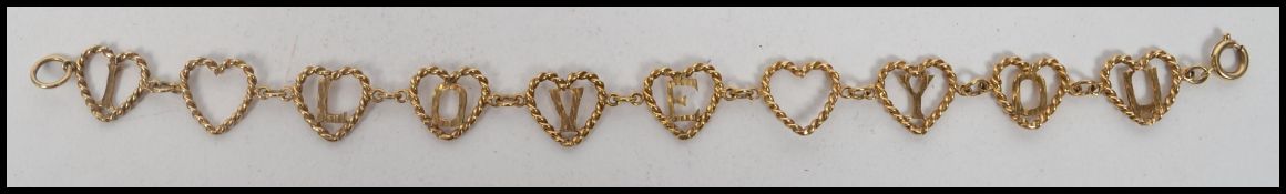A hallmarked 9ct bracelet chain having robe twist heart shaped spacers with lettering reading I Love