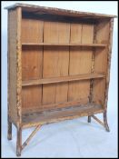 A Victorian aesthetic movement bamboo open window bookcase cabinet having fixed shelves with