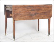 A Georgian 19th century mahogany drop leaf pembroke table being raised on squared legs with