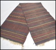 A large Afghan / Persian Balouch Kilim runner rug having dark central ground with central spiral