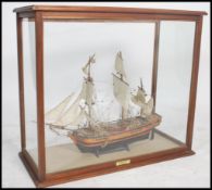 A wooden cased model ship of HMS Bounty complete and mounted in a large oak and glass display